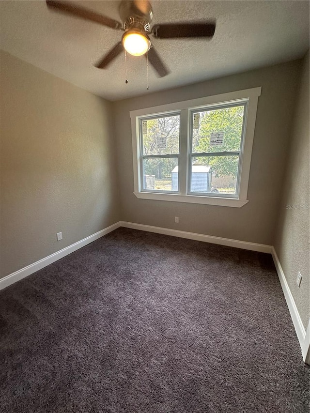 carpeted empty room featuring a textured ceiling, a healthy amount of sunlight, and ceiling fan