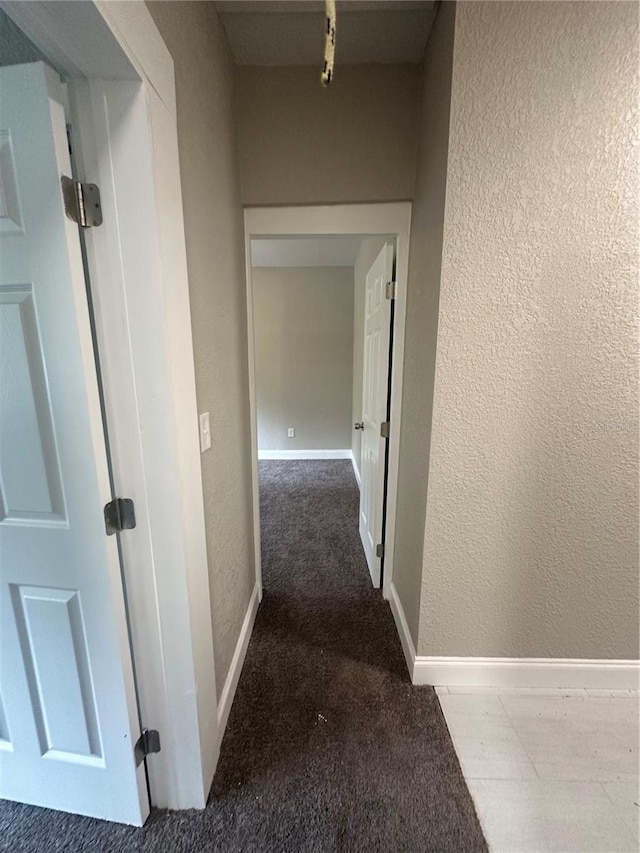 hallway featuring dark carpet