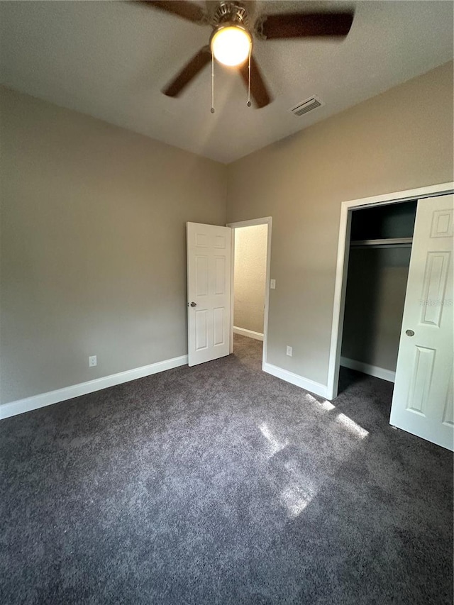 unfurnished bedroom featuring a closet, ceiling fan, and dark carpet