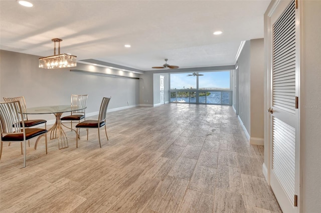 dining space featuring ceiling fan with notable chandelier and light hardwood / wood-style flooring