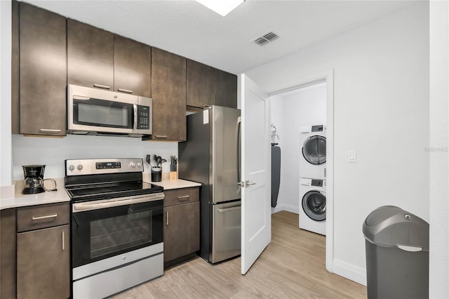 kitchen featuring dark brown cabinetry, appliances with stainless steel finishes, and light wood-type flooring