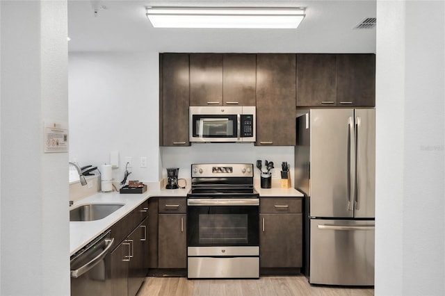 kitchen featuring light hardwood / wood-style floors, stainless steel appliances, dark brown cabinets, and sink