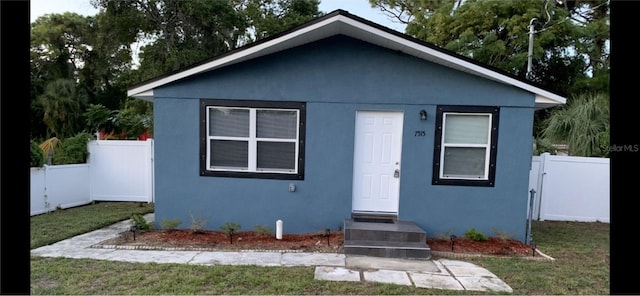 bungalow-style home with a front lawn