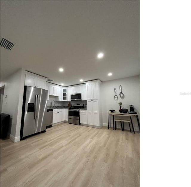 kitchen featuring white cabinets, light hardwood / wood-style floors, stainless steel appliances, and sink