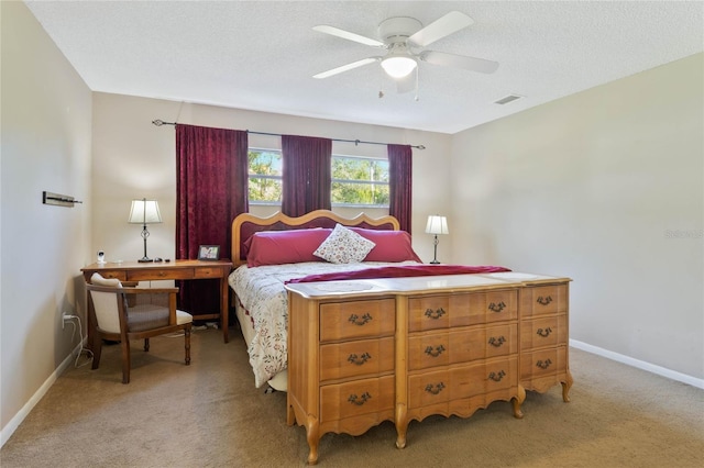 bedroom featuring ceiling fan, light colored carpet, and a textured ceiling