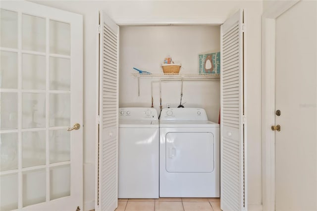 laundry room with washer and dryer and light tile patterned flooring