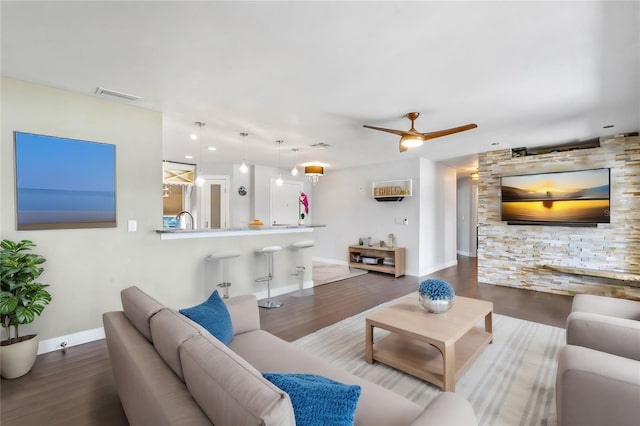 living room with ceiling fan and dark hardwood / wood-style flooring