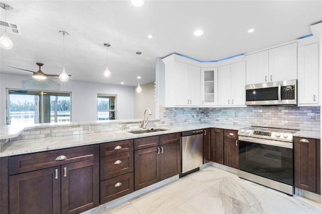 kitchen featuring sink, stainless steel appliances, hanging light fixtures, and backsplash