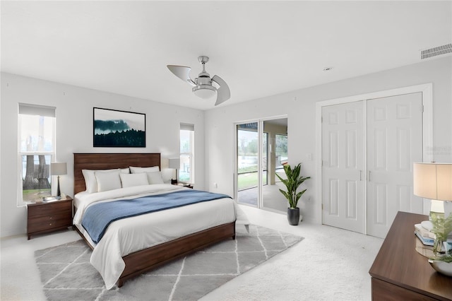 carpeted bedroom featuring multiple windows, ceiling fan, and access to outside