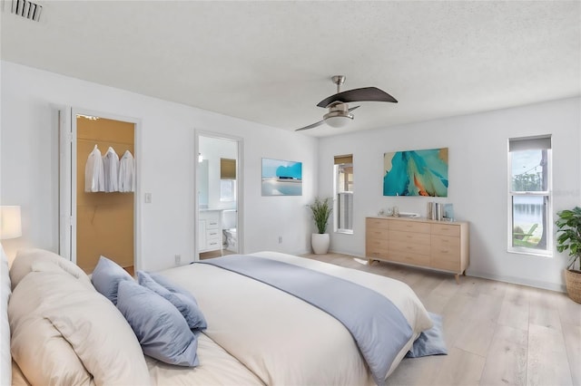 bedroom with light hardwood / wood-style flooring, ceiling fan, ensuite bathroom, a textured ceiling, and a closet