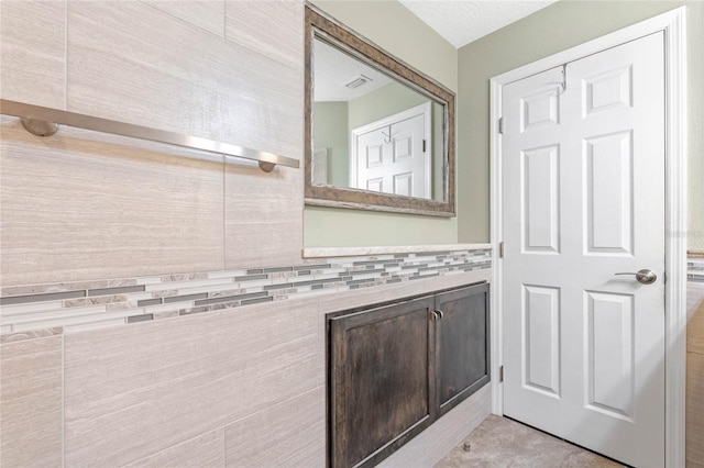 bathroom featuring a textured ceiling and tile patterned floors