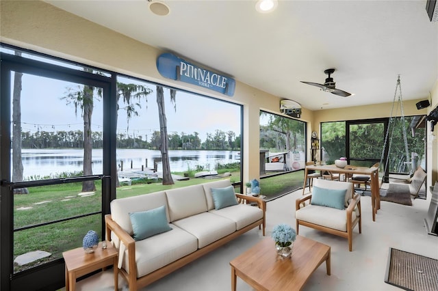 sunroom / solarium with ceiling fan and a water view