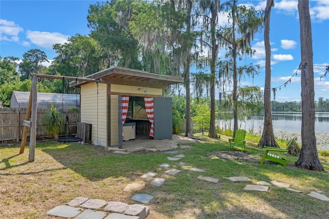 view of yard featuring a water view and a shed