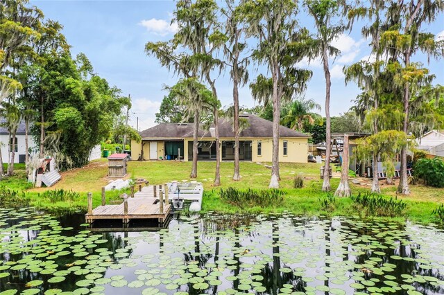 rear view of property featuring a water view and a yard