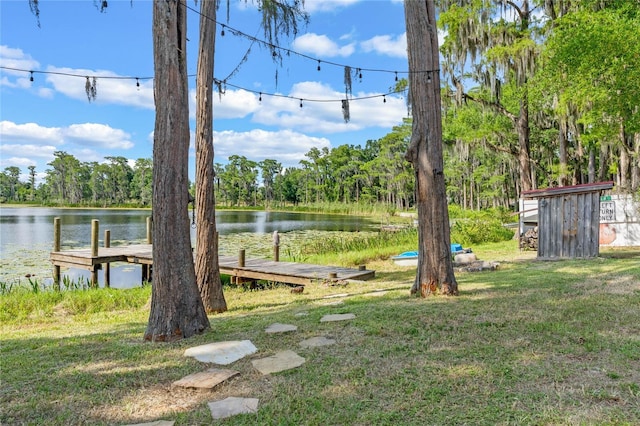 view of yard with a boat dock and a water view