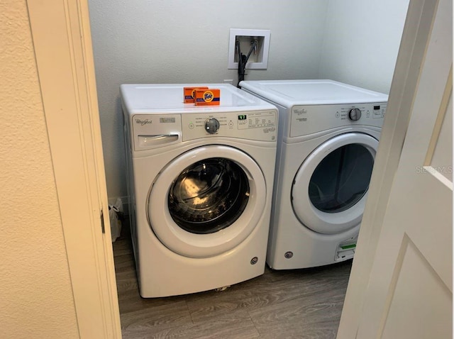 laundry area with independent washer and dryer and dark hardwood / wood-style floors