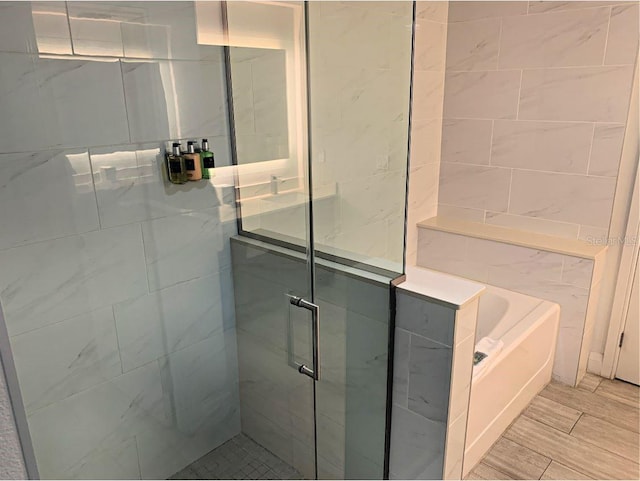 bathroom featuring independent shower and bath and hardwood / wood-style flooring