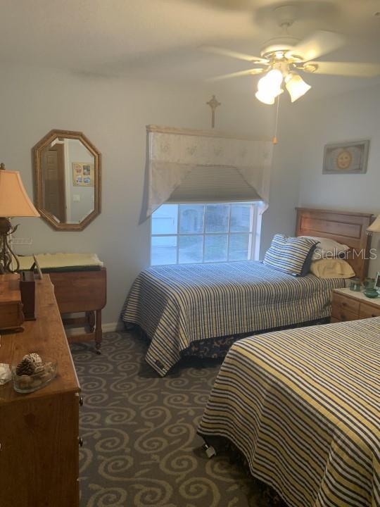 bedroom with dark colored carpet and ceiling fan