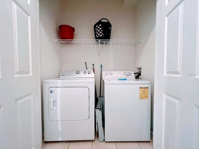 washroom featuring separate washer and dryer and light tile patterned floors