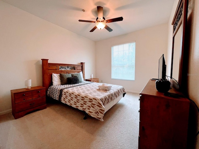 bedroom featuring vaulted ceiling, light colored carpet, and ceiling fan