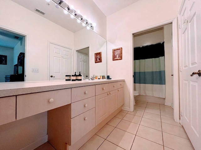 bathroom featuring vanity, tile patterned floors, and toilet