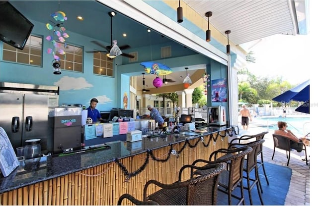 view of patio / terrace featuring ceiling fan and a bar