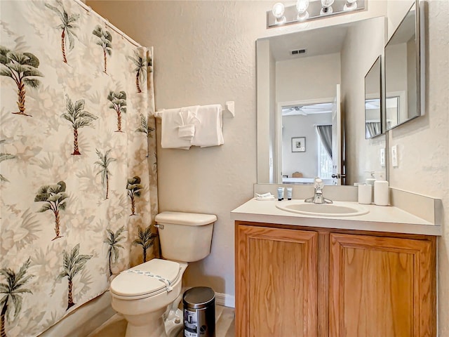 bathroom with oversized vanity, toilet, and ceiling fan