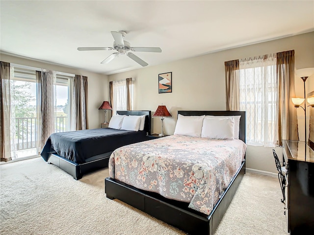 bedroom with light carpet, multiple windows, ceiling fan, and access to outside