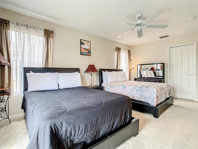 carpeted bedroom featuring multiple windows, a closet, and ceiling fan