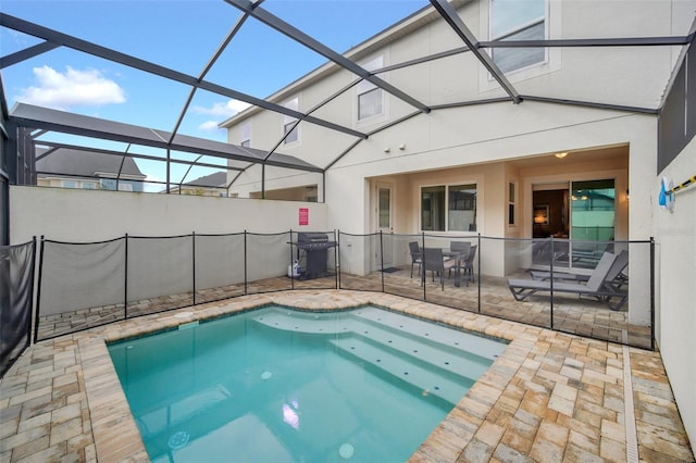 view of pool with a lanai, a patio, and a grill