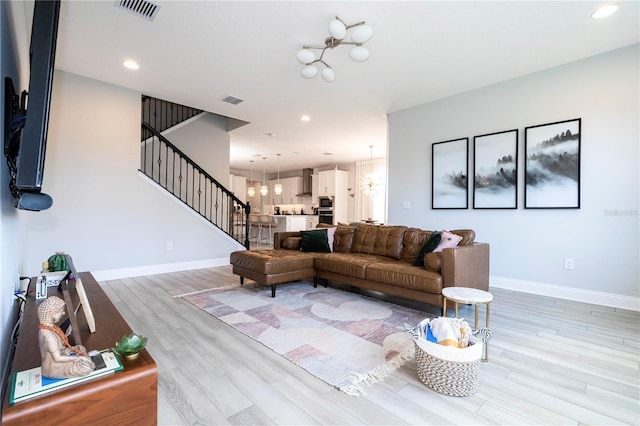 living room with a chandelier and light hardwood / wood-style floors