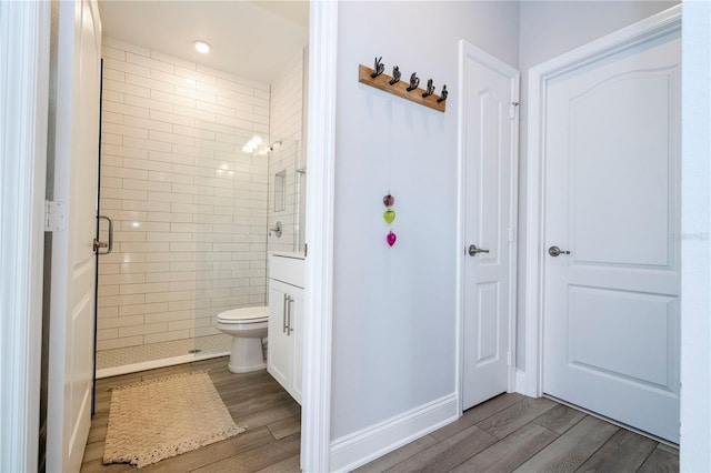 bathroom with walk in shower, toilet, and hardwood / wood-style flooring