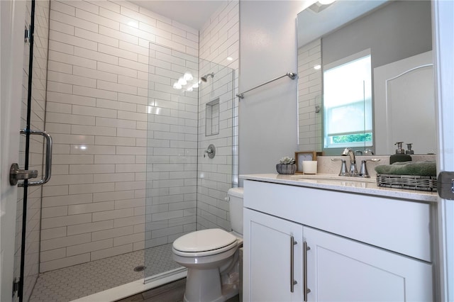 bathroom with toilet, large vanity, and walk in shower