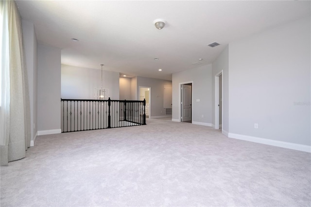 carpeted empty room with a chandelier