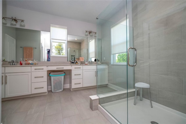 bathroom with double vanity, tile floors, and a shower with shower door