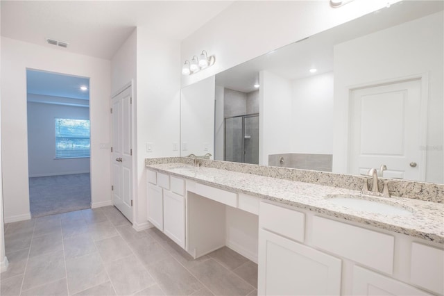 bathroom featuring vanity, tile patterned flooring, and a shower with shower door