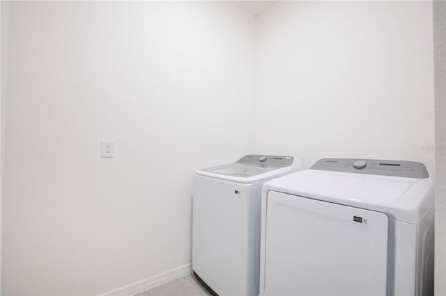 washroom with light tile patterned flooring and washer and dryer