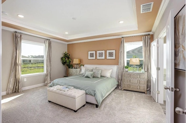 bedroom featuring crown molding, light colored carpet, and a tray ceiling