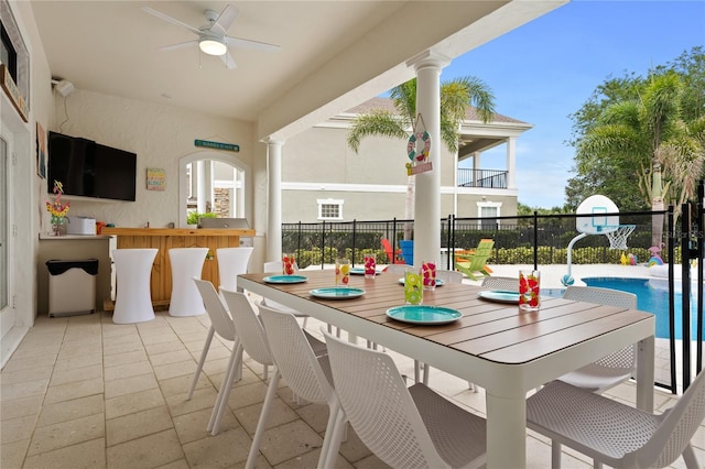 view of patio featuring ceiling fan, a fenced in pool, and exterior bar