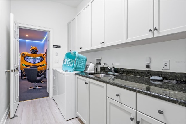 washroom featuring cabinets, light wood-type flooring, separate washer and dryer, and sink