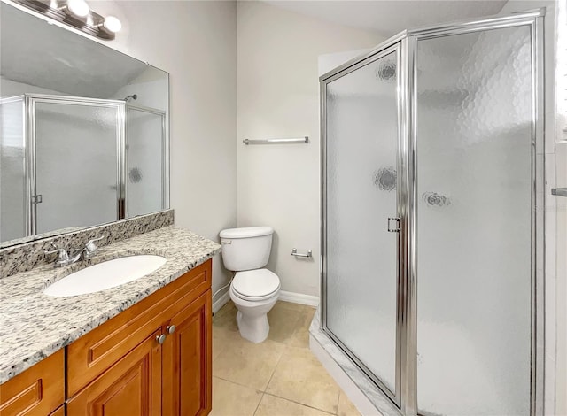 bathroom featuring vanity, baseboards, a stall shower, tile patterned flooring, and toilet