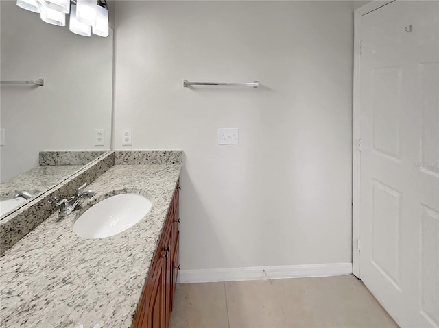 bathroom with baseboards, vanity, and tile patterned flooring