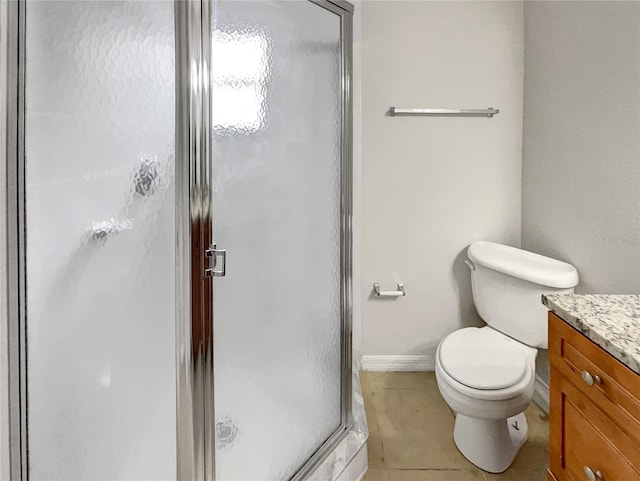 bathroom featuring vanity, toilet, baseboards, and a stall shower