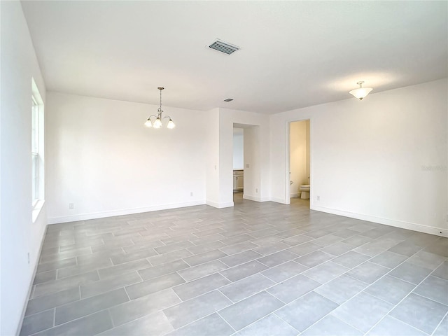 empty room featuring an inviting chandelier