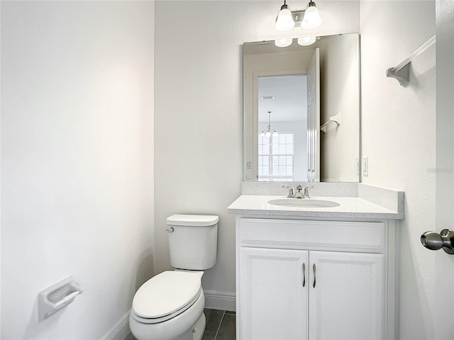 bathroom featuring tile patterned flooring, vanity, toilet, and a notable chandelier