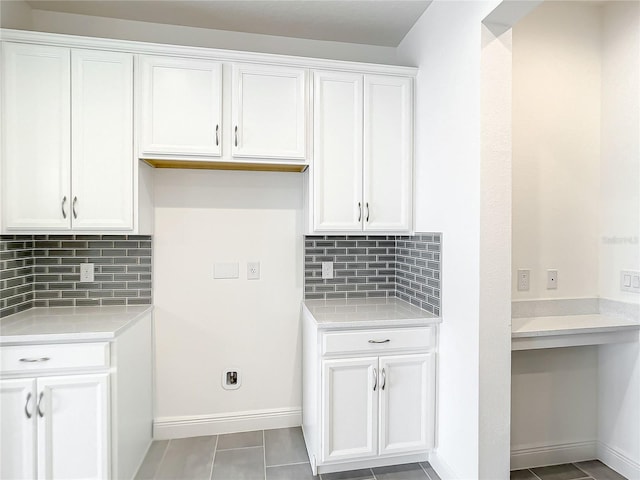 clothes washing area with light tile patterned floors