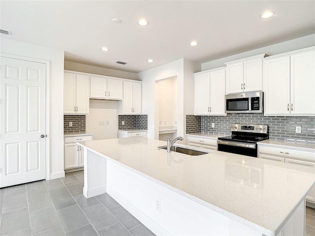 kitchen featuring white cabinetry, a kitchen island with sink, sink, and stainless steel appliances