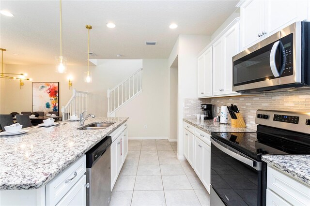 kitchen with tasteful backsplash, stainless steel appliances, white cabinetry, and sink