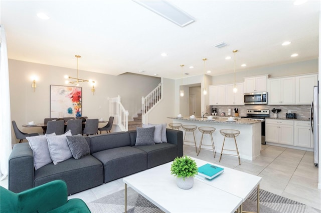 living room featuring light tile floors and a chandelier