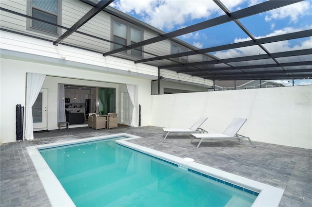 view of swimming pool featuring a patio area and glass enclosure